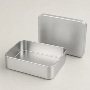 Unbranded aluminum candle and soap box on a warm gray studio background