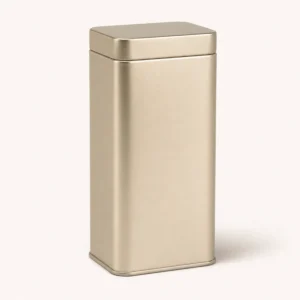 Unbranded elegant hinged tea tin on a warm gray studio background