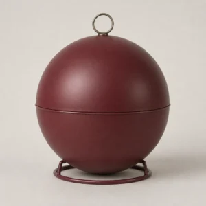 Unbranded festive ball tin box on a warm gray studio background