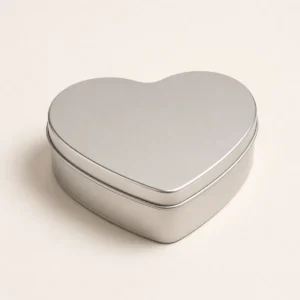 Unbranded heart shape tin box on a warm gray studio background