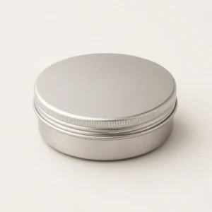 Unbranded round cream and wax tin on a warm gray studio background