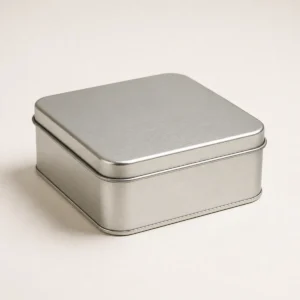 Unbranded square tin box on a warm gray studio background